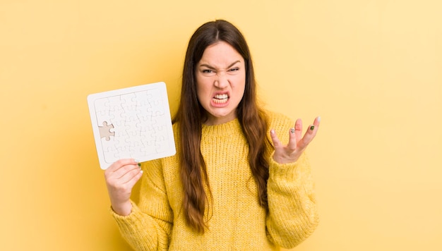 Jeune jolie femme à la recherche de concept de puzzle ennuyé et frustré en colère