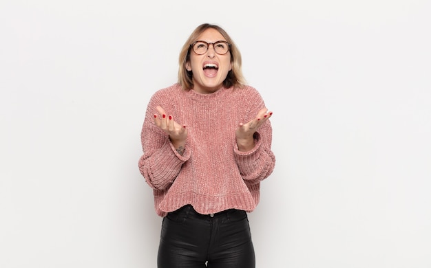 Jeune jolie femme à la recherche désespérée et frustrée, stressée, malheureuse et agacée, criant et hurlant