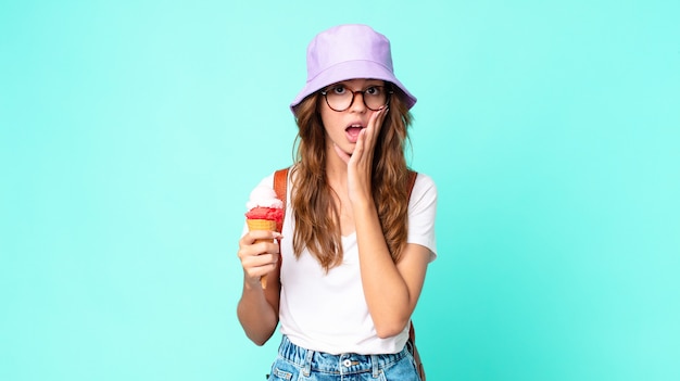 Jeune jolie femme se sentant choquée et effrayée tenant une glace. concept d'été