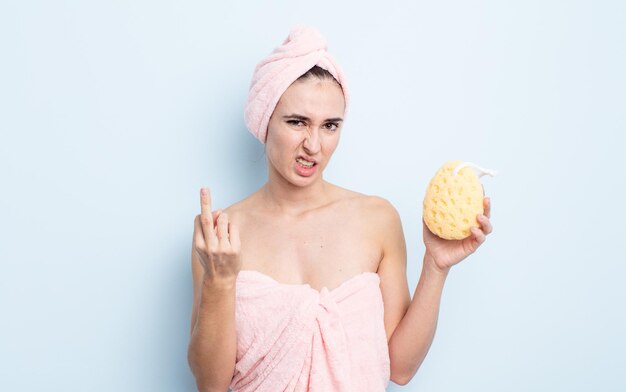 Jeune jolie femme se sentant en colère, agacée, rebelle et agressive. concept de douche et éponge