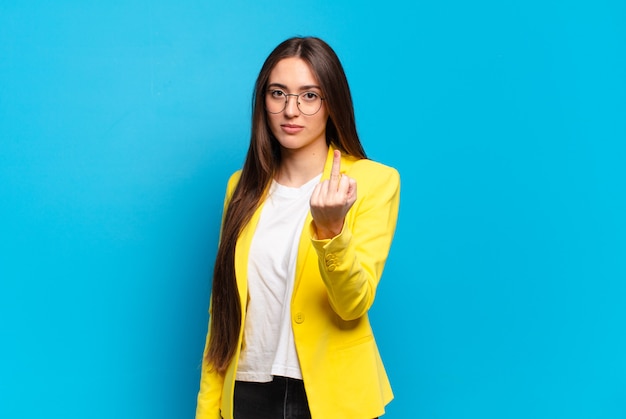 Jeune jolie femme se sentant en colère, agacée, rebelle et agressive, retournant le majeur, ripostant