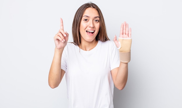 Jeune jolie femme se sentant comme un génie heureux et excité après avoir réalisé une idée. concept de bandage à la main