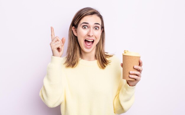 Jeune jolie femme se sentant comme un génie heureux et excité après avoir réalisé une idée. concept de café à emporter