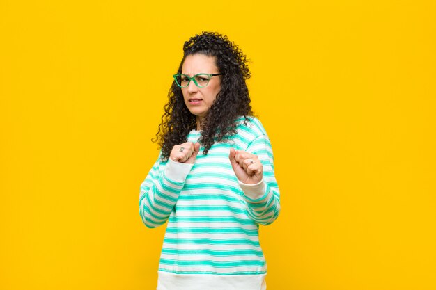 Jeune jolie femme se sentant dégoûtée et nauséeuse, reculant devant quelque chose de méchant disant beurk contre le mur orange