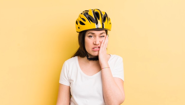 Jeune jolie femme se sentant ennuyée, frustrée et somnolente après un concept de casque de vélo fastidieux