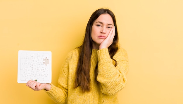 Jeune jolie femme se sentant ennuyée, frustrée et somnolente après un concept de puzzle fastidieux