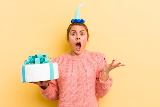 Jeune jolie femme se sentant extrêmement choquée et surprise du concept d'anniversaire