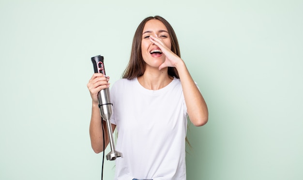 Jeune jolie femme se sentant heureuse, donnant un grand cri avec les mains à côté de la bouche. concept de mélangeur à main