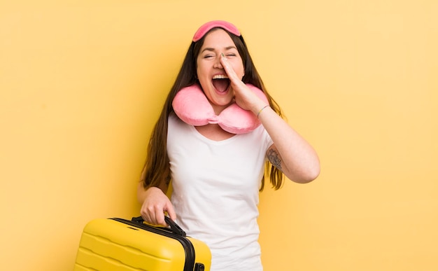 Jeune jolie femme se sentant heureuse en donnant un grand cri avec les mains à côté de la bouche concept de passager de vol