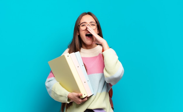 Jeune Jolie Femme Se Sentant Heureuse, Excitée Et Positive, Donnant Un Grand Cri Avec Les Mains à Côté De La Bouche, Appelant