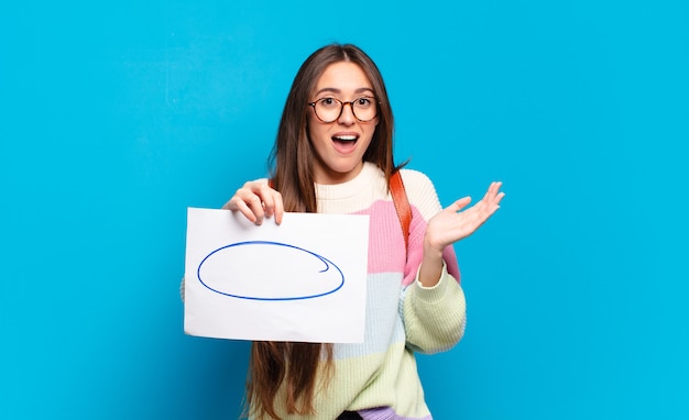 Jeune jolie femme se sentant heureuse, excitée, surprise ou choquée, souriante et étonnée de quelque chose d'incroyable