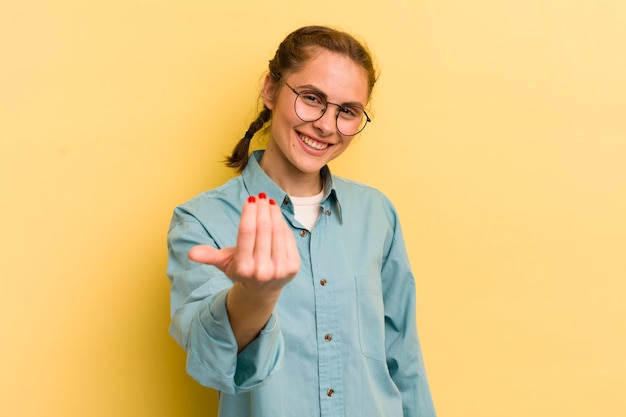 Jeune jolie femme se sentant heureuse, réussie et confiante face à un défi et disant de l'amener ou de vous souhaiter la bienvenue