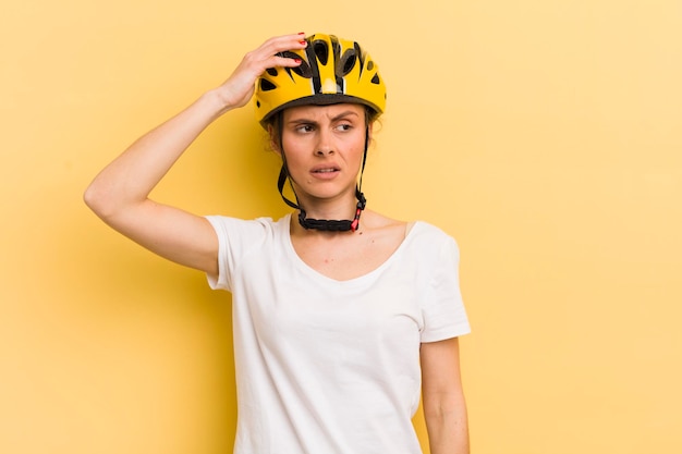 Jeune jolie femme se sentant perplexe et confuse se grattant le concept de vélo de tête