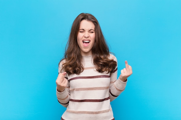 Jeune jolie femme se sentant provocante, agressive et obscène, retournant le majeur, avec une attitude rebelle