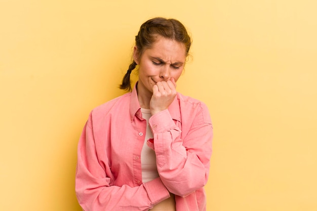 Jeune jolie femme se sentant sérieuse, réfléchie et inquiète, regardant de côté avec la main appuyée contre le menton