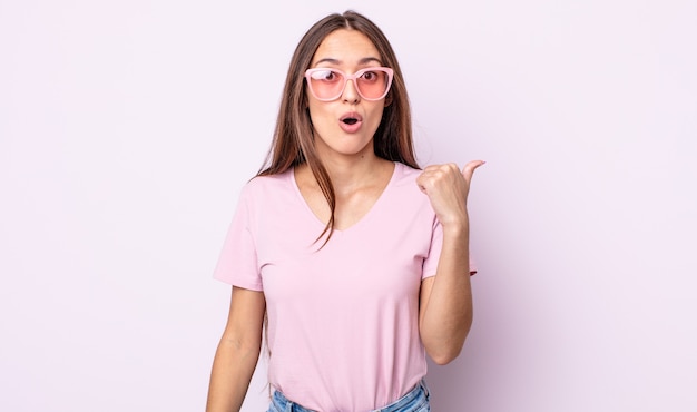 Jeune jolie femme semblant étonnée d'incrédulité. concept de lunettes de soleil roses