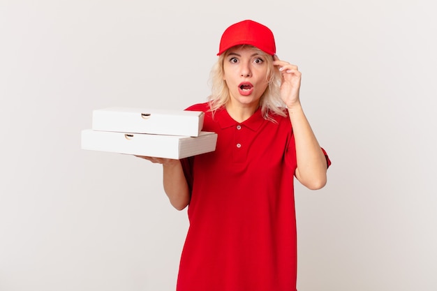 Jeune jolie femme semblant surprise, réalisant une nouvelle pensée, idée ou concept. concept de livraison de pizza