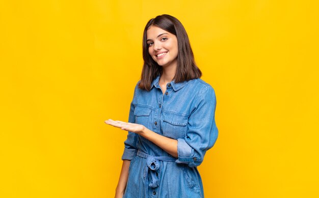 Jeune jolie femme souriant joyeusement, se sentant heureux