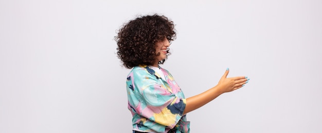 Jeune jolie femme souriante aux cheveux bouclés