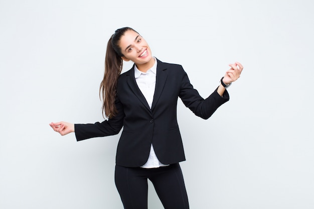 Jeune jolie femme souriante, insouciante, détendue et heureuse, dansant et écoutant de la musique, s'amusant dans un concept d'entreprise de fête