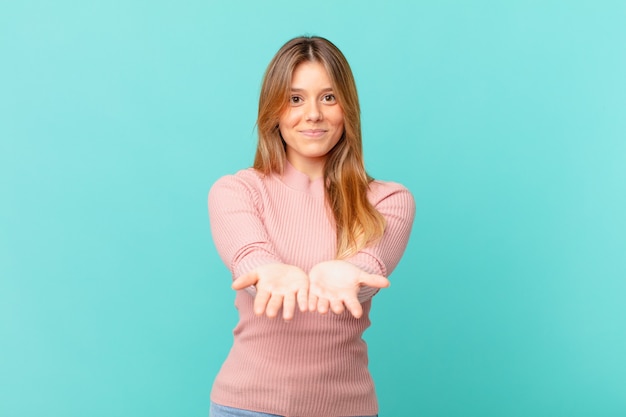 Jeune jolie femme souriante joyeusement avec amicale et offrant et montrant un concept