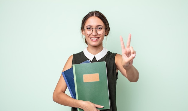 Jeune jolie femme souriante et semblant heureuse, gesticulant la victoire ou la paix. concept universitaire