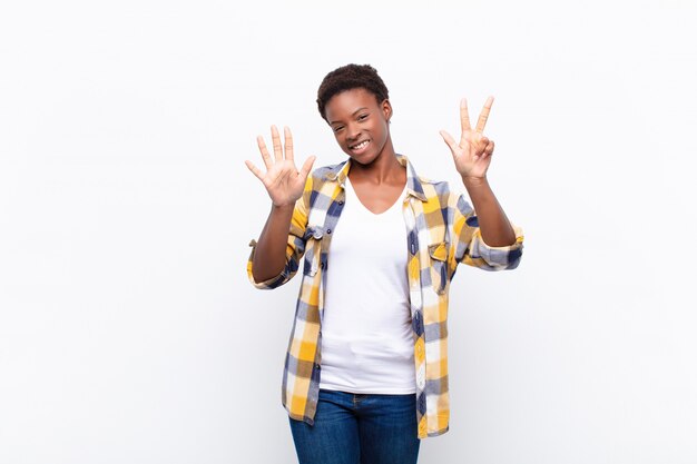 Jeune jolie femme souriante et sympathique, montrant le numéro huit ou huitième avec la main vers l'avant, compte à rebours