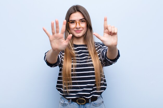 Jeune jolie femme souriante et sympathique, montrant le numéro sept