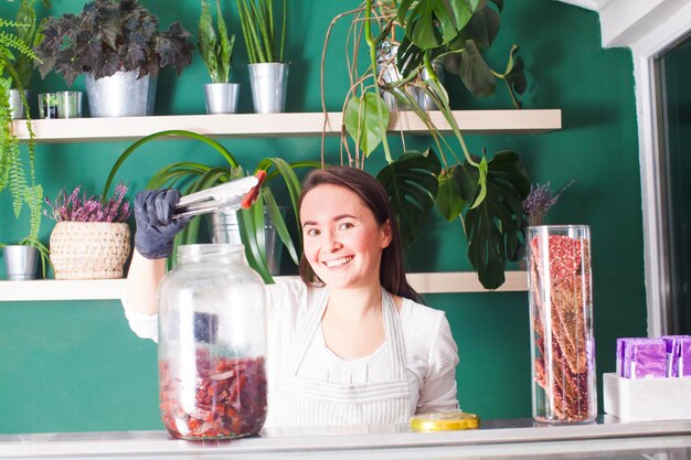 La jeune jolie femme sourit au travail dans l'épicerie