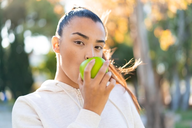 Jeune jolie femme sportive tenant une pomme