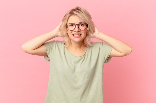 Photo jeune jolie femme stressée, anxieuse ou effrayée, les mains sur la tête