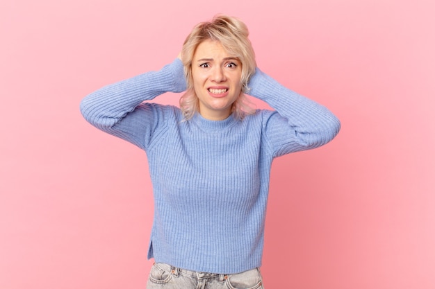 Jeune jolie femme stressée, anxieuse ou effrayée, les mains sur la tête