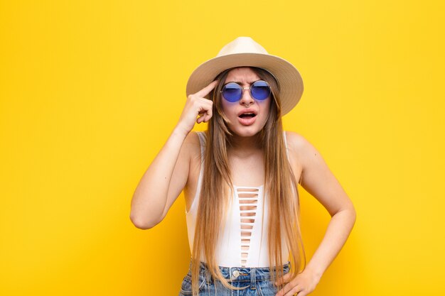 Jeune jolie femme à la surprise, bouche bée, choquée, réalisant une nouvelle pensée, idée ou concept