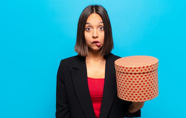 Jeune jolie femme tenant une boîte-cadeau