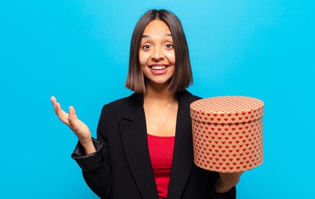 Jeune jolie femme tenant une boîte-cadeau