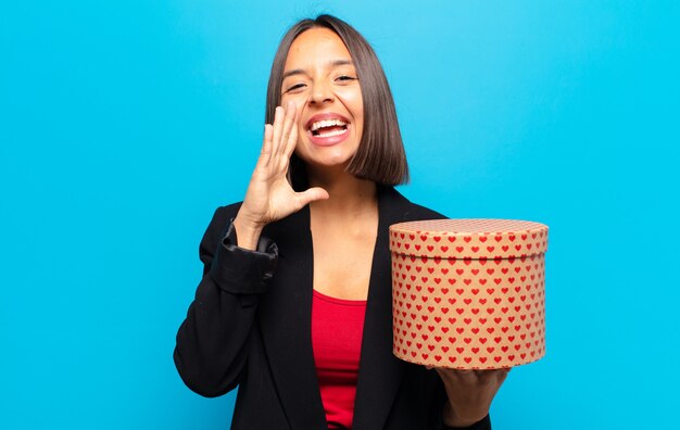 Jeune jolie femme tenant une boîte-cadeau