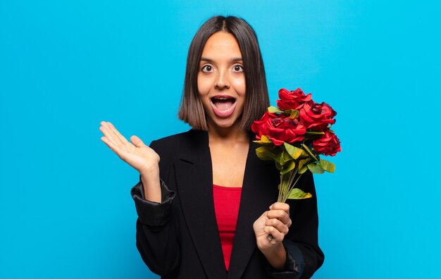 Jeune jolie femme tenant un bouquet de roses