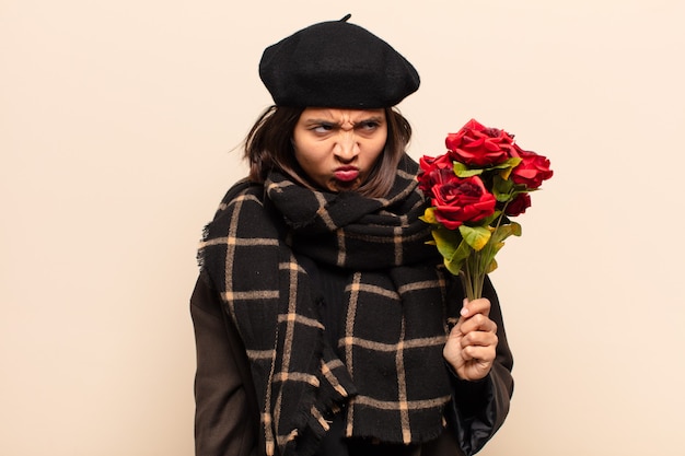 Jeune jolie femme tenant un bouquet de roses