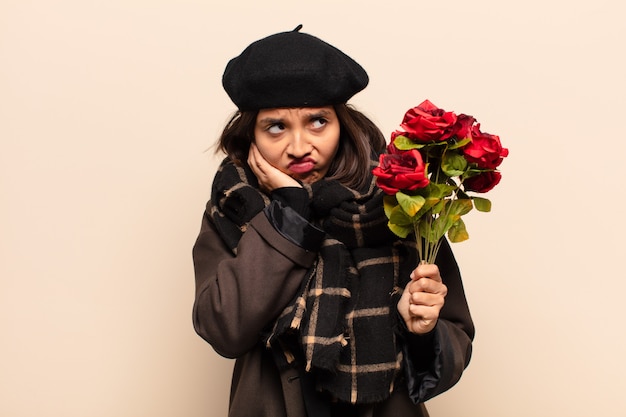 Jeune jolie femme tenant un bouquet de roses