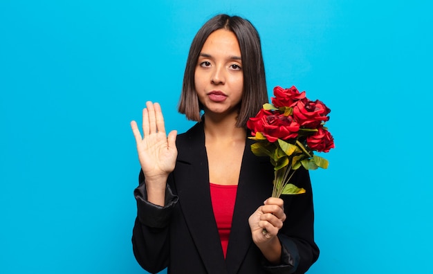 Jeune jolie femme tenant un bouquet de roses