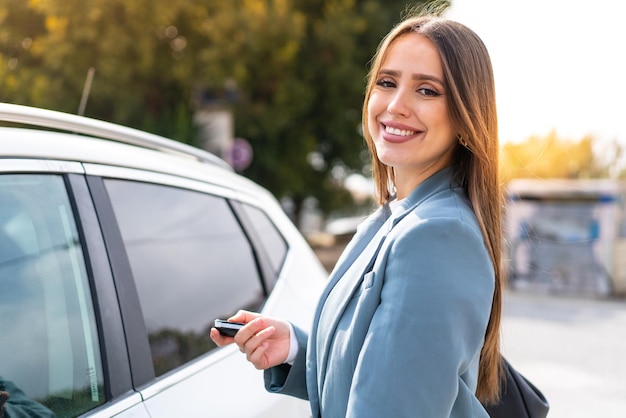 Jeune jolie femme tenant des clés de voiture à l'extérieur