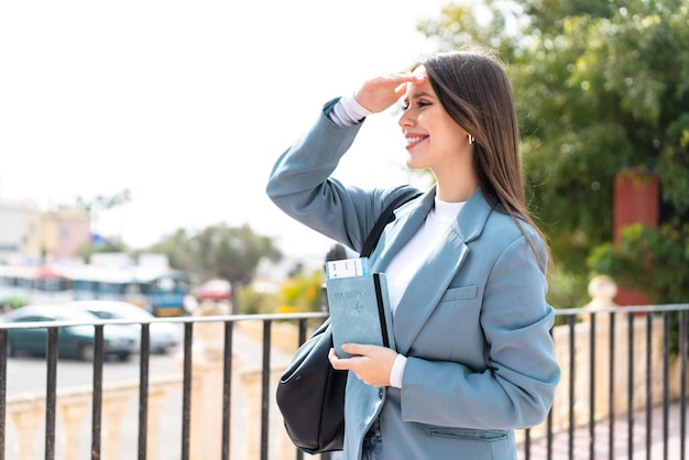 Jeune jolie femme tenant un passeport à l'extérieur