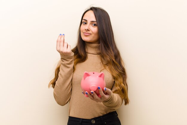 Jeune jolie femme avec une tirelire