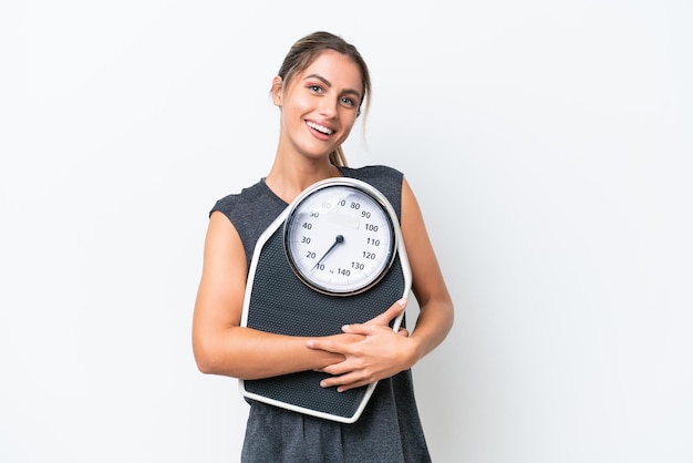 Jeune jolie femme uruguayenne isolée sur fond blanc avec balance