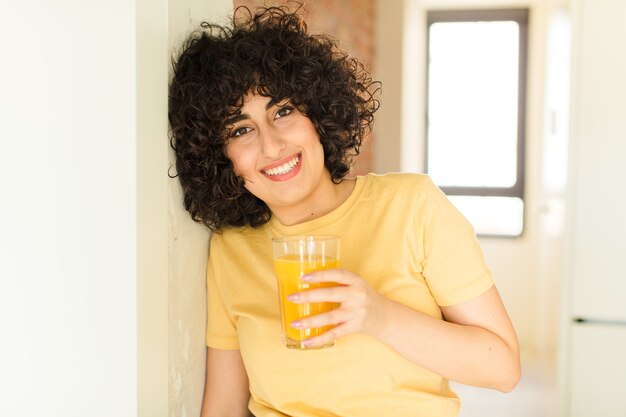 Jeune jolie femme avec un verre de jus d'orange