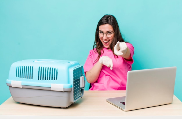 jeune jolie femme vétérinaire avec un ordinateur portable et une cage pour animaux de compagnie