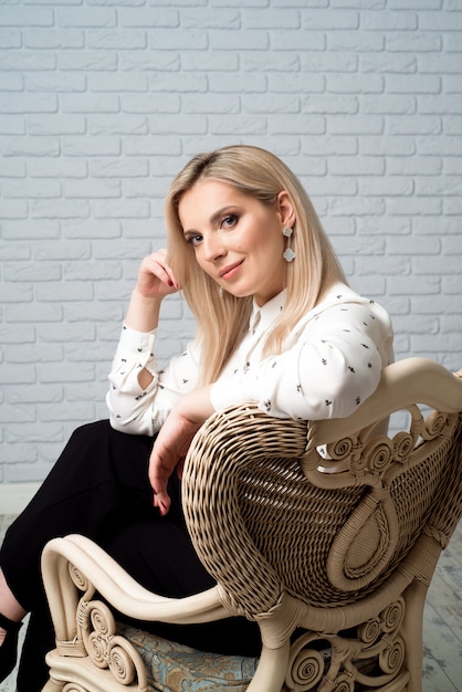 Jeune jolie femme vêtue d'une chemise blanche. Fond de studio.