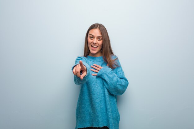 Jeune jolie femme vêtue d’un pull bleu rêve d’atteindre ses objectifs