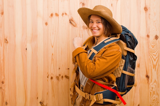 Jeune jolie femme voyageur latine contre le mur en bois