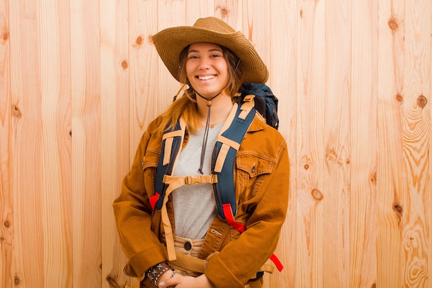 Jeune jolie femme voyageur latine contre le mur en bois